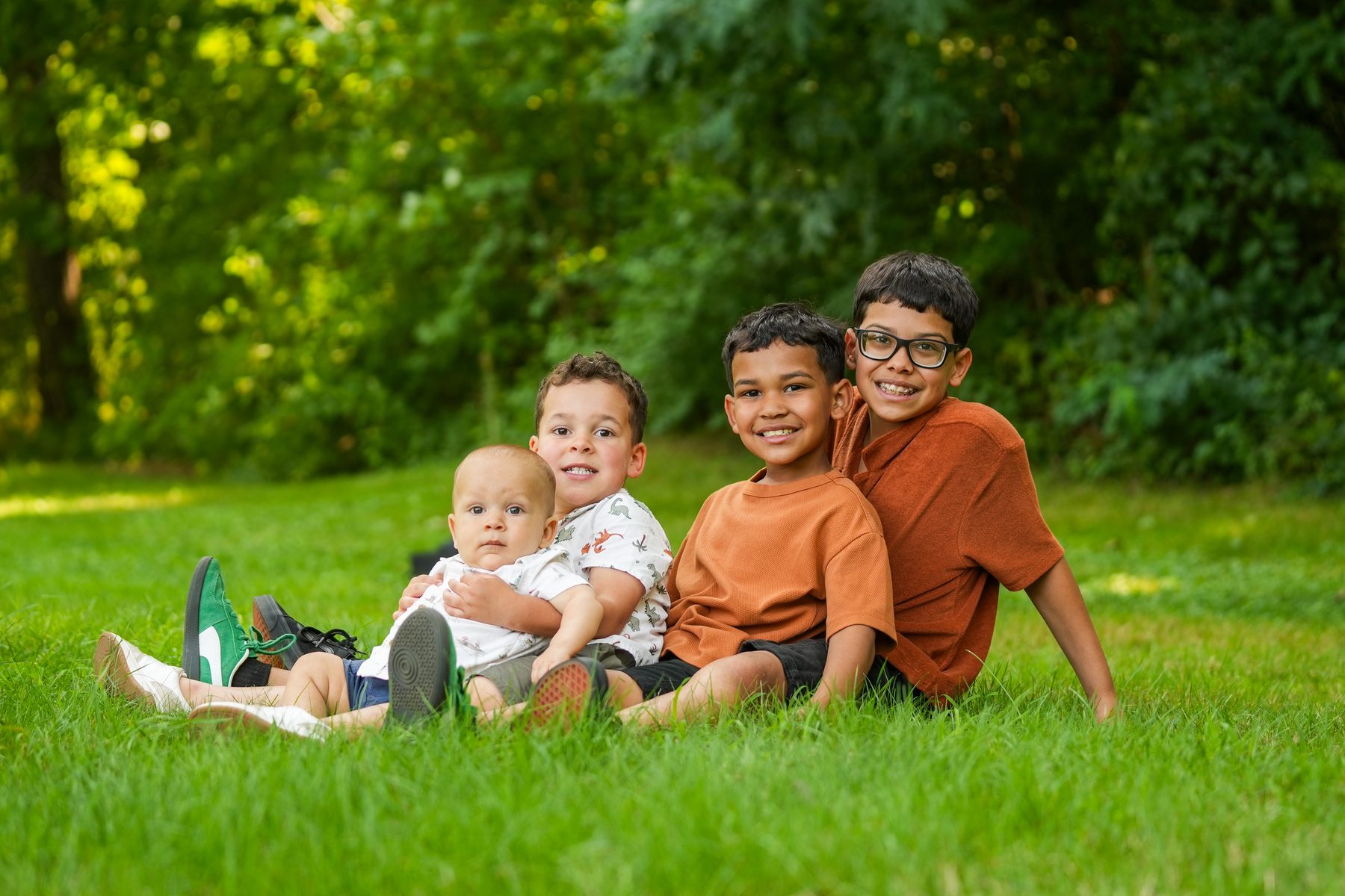 Family portrait of four brothers sitting together on the grass in Western Massachusetts