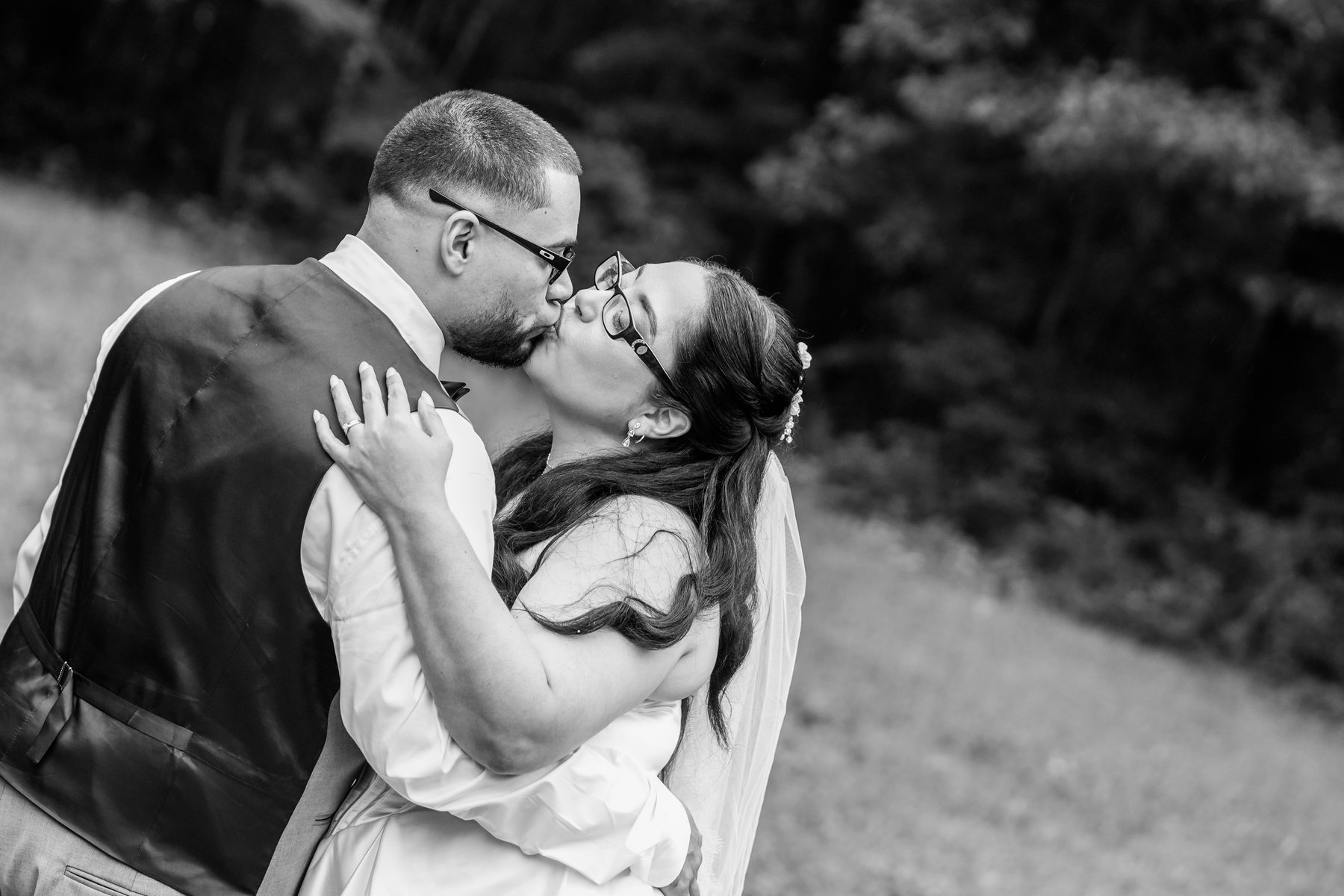 Bride and groom sharing their first kiss, black and white wedding photo in Western Massachusetts by ShotByLessard