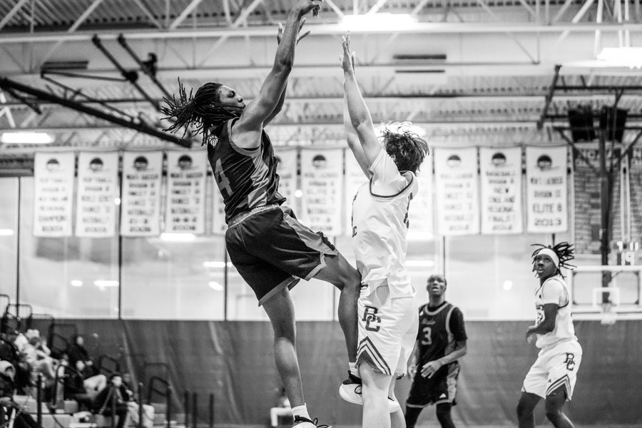 Black and white photo of a high school basketball player shooting a jump shot