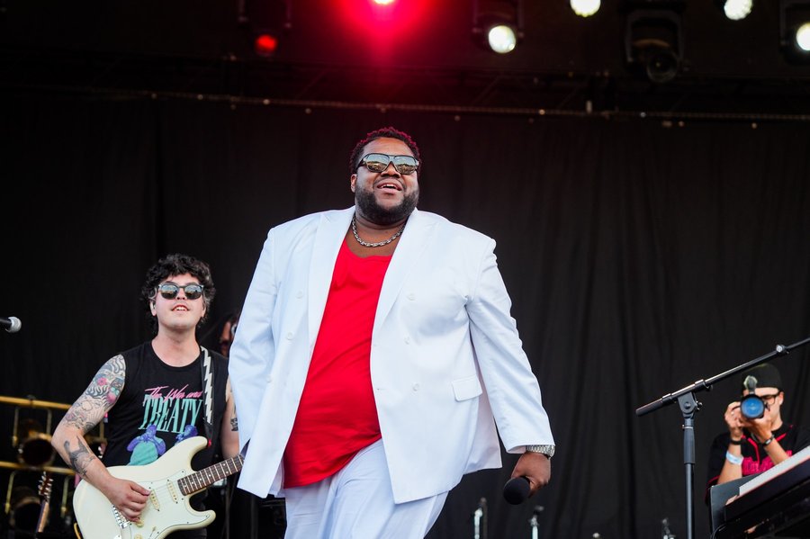 Michael Trotter Jr. of The War and Treaty performing center stage at a festival