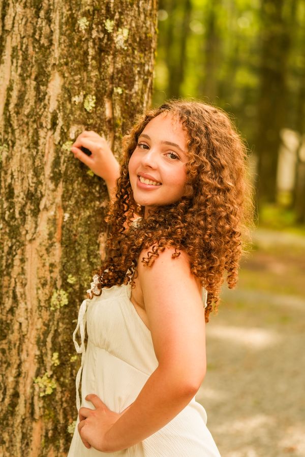 High school senior portrait in a forest wearing a white dress in West Springfield, Massachusetts