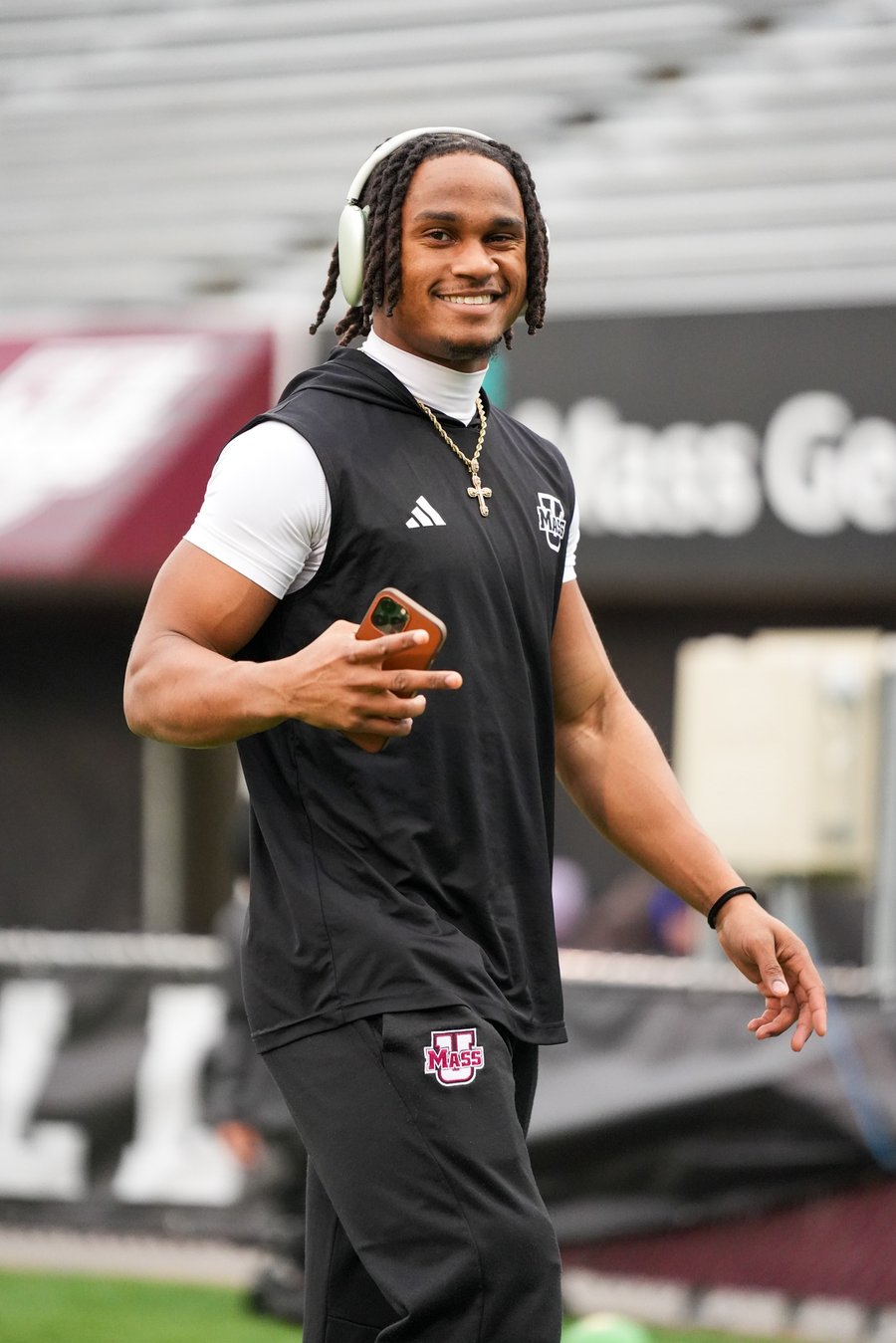 UMass football player arriving on game day, candid portrait with headphones