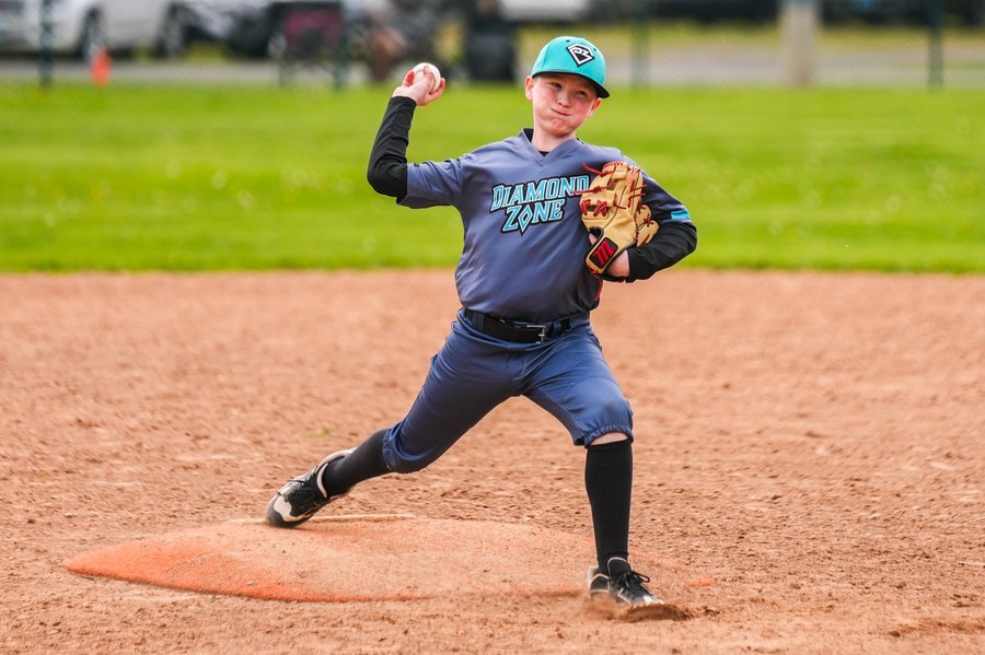 Youth baseball pitcher delivering a pitch during a game in Western Mass